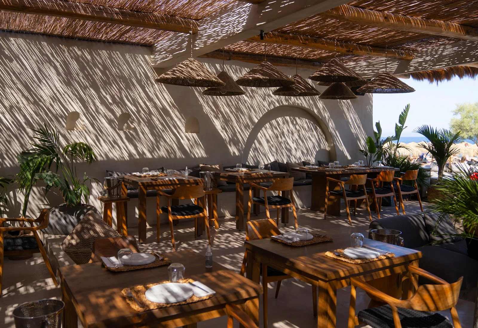 A stylish beach bar with loungers on the black sand at Perivolos, Perissa, at dusk