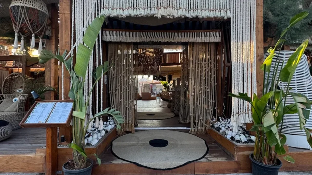 The macramé-draped entrance of JoJo beach bar on the black sand at Perivolos, next to Perissa