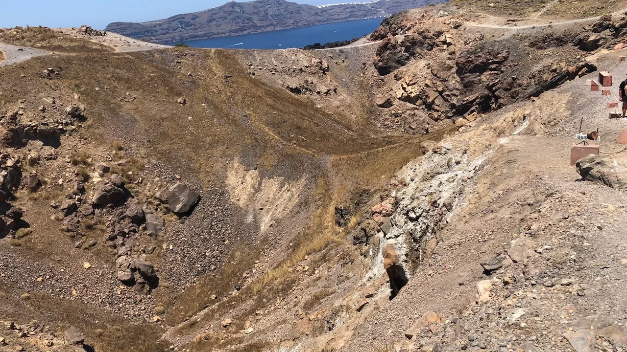 The black volcanic crater of Nea Kameni rising from the Santorini caldera, seen on a volcano boat tour