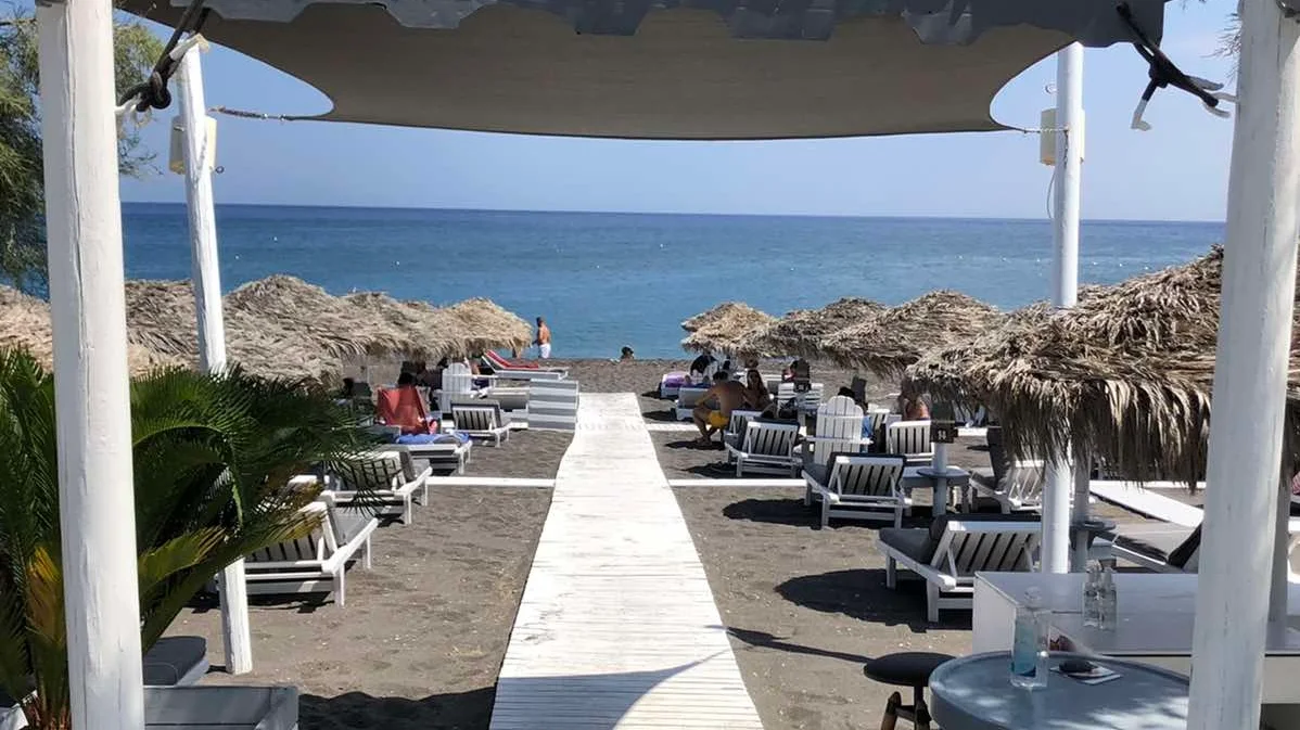 Sunbeds and thatched umbrellas at Chilli Beach Bar, Perivolos, Santorini