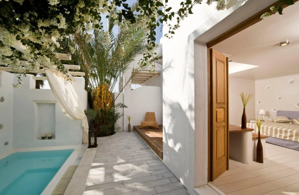 A private courtyard with a plunge pool and bougainvillea at Meltemi Village in Perissa, Santorini