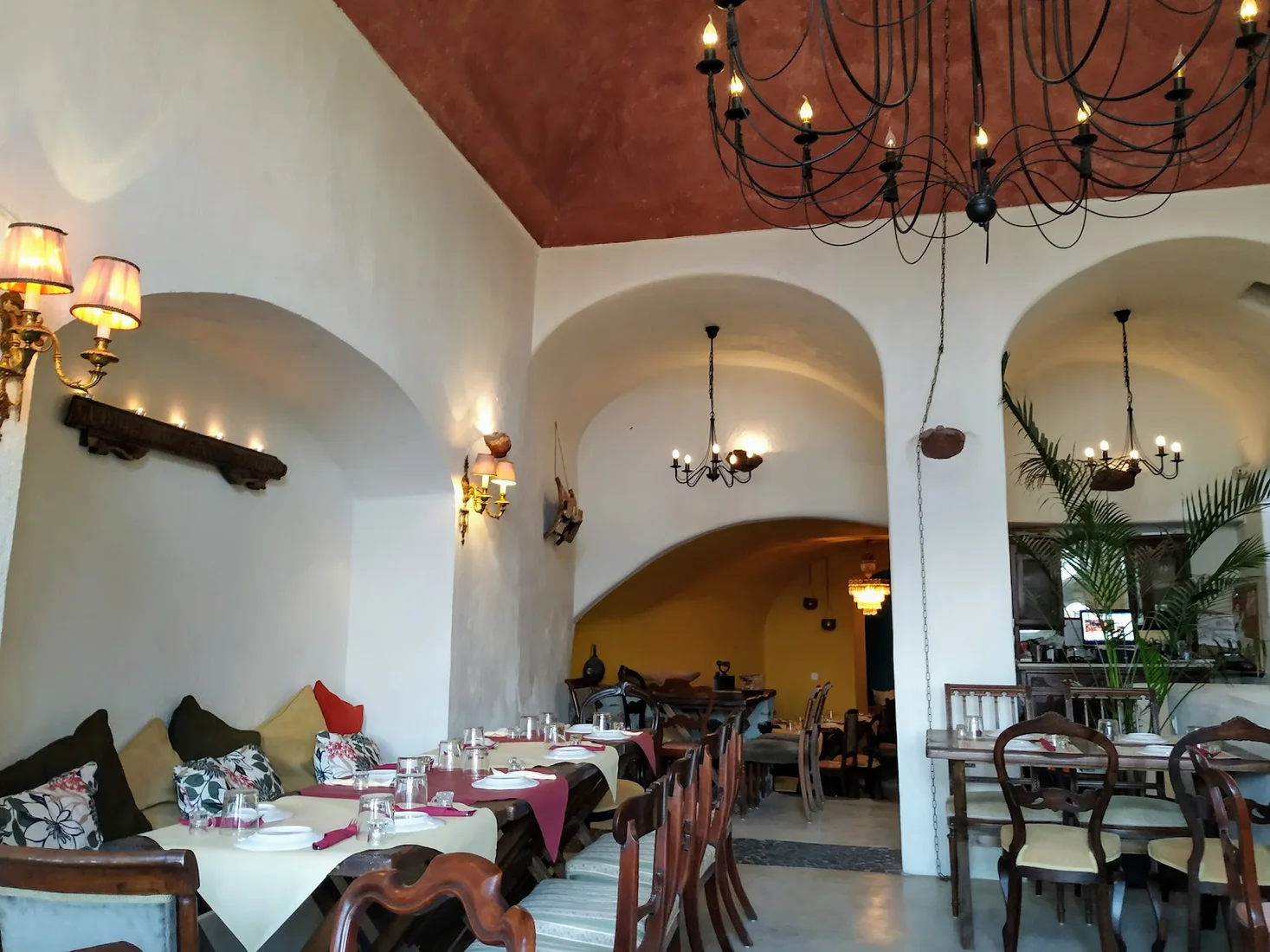 The whitewashed, arch-vaulted dining room with a wrought-iron chandelier at Cava Alta near Pyrgos, Santorini