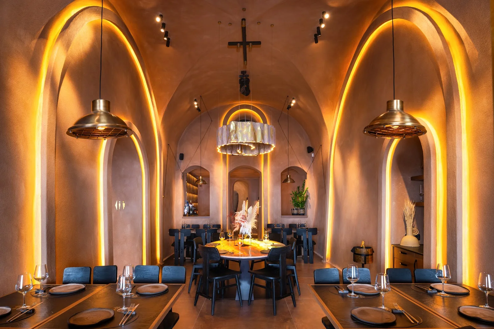 The cave-vaulted, warmly lit dining room of Rizes Gastro Taverna in Fira, Santorini
