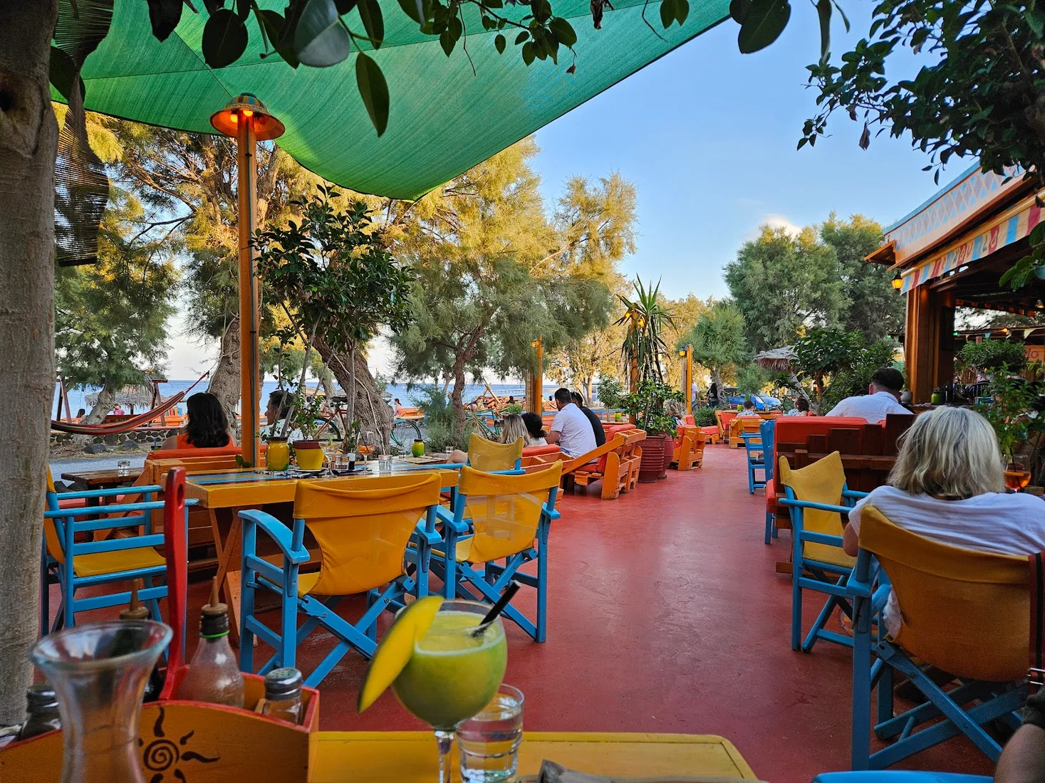 The shaded, colourful beachfront terrace of Tranquilo vegetarian café in Perissa, Santorini