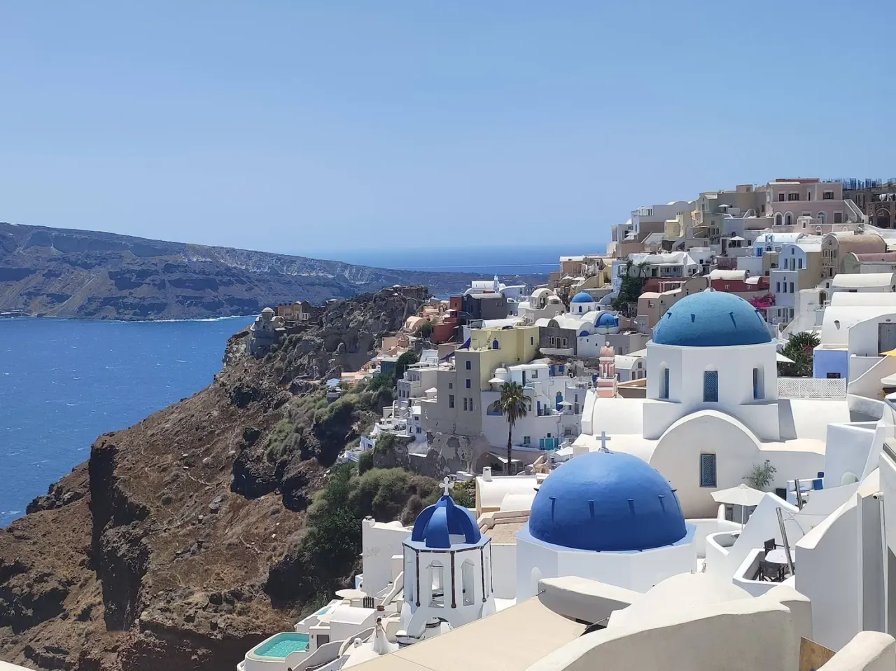 The whitewashed cliff-top village of Oia at sunset, a day trip from Perissa on Santorini