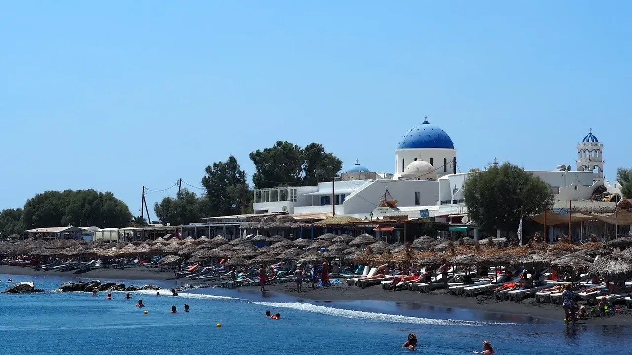 The long black-sand beach of Perissa below the rock of Mesa Vouno, Santorini