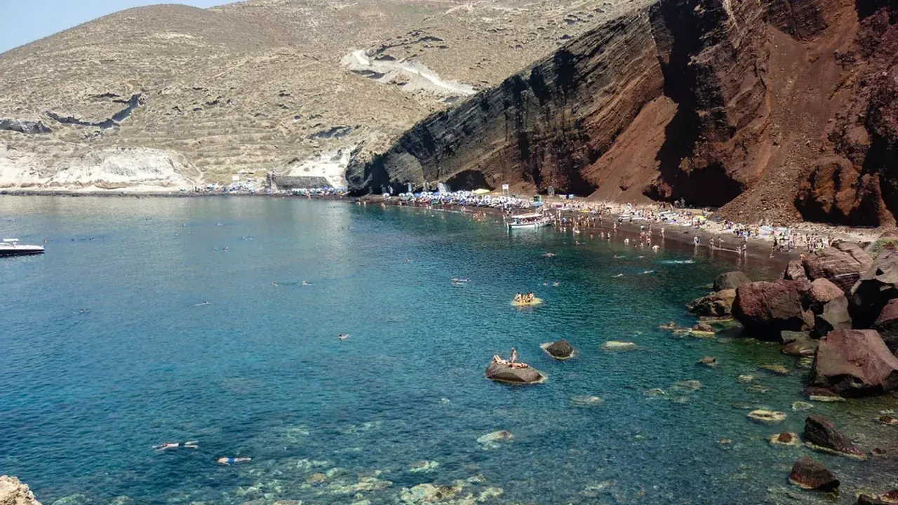 The red volcanic cliffs and swimming cove of Santorini's Red Beach near Akrotiri