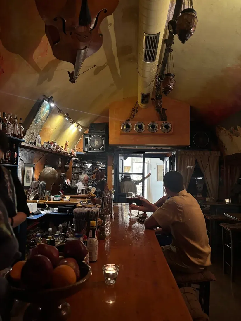 The vaulted ochre interior of Kira Thira jazz bar in Fira, with a double bass hung from the ceiling