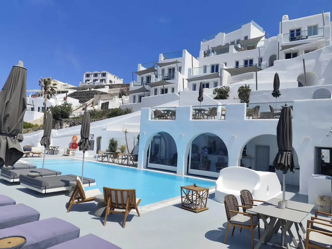 The white terraced suites and pool of Belvedere Suites above the caldera and Skaros Rock in Firostefani, Santorini