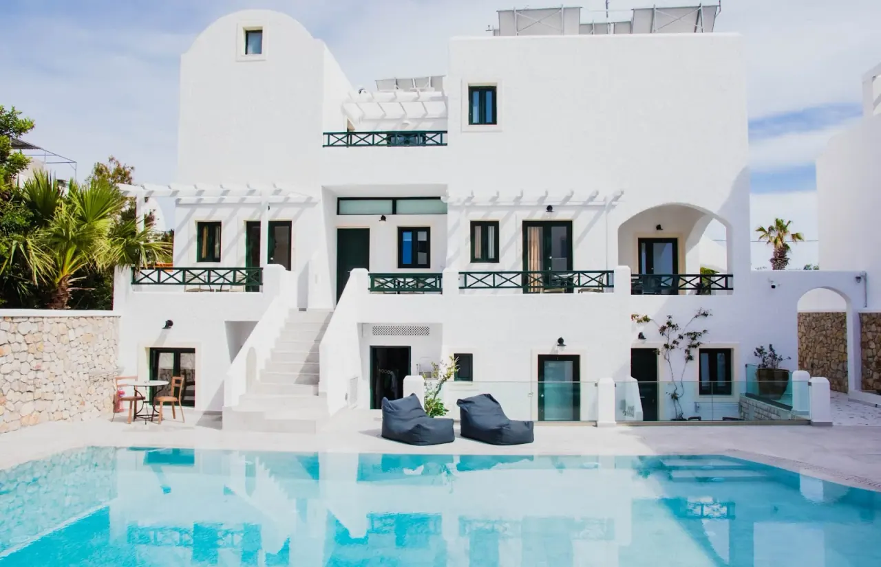 The white Cycladic buildings and pool of Sellada Beach Hotel in Perissa, Santorini