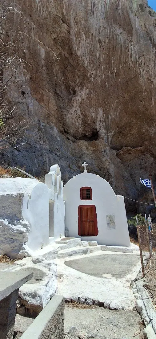 The whitewashed rock chapel of Panagia Katefiani built into the cliff face of Mesa Vouno above Perissa