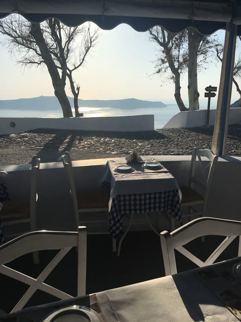A single set table on the caldera-view terrace of Aktaion restaurant in Firostefani, Santorini