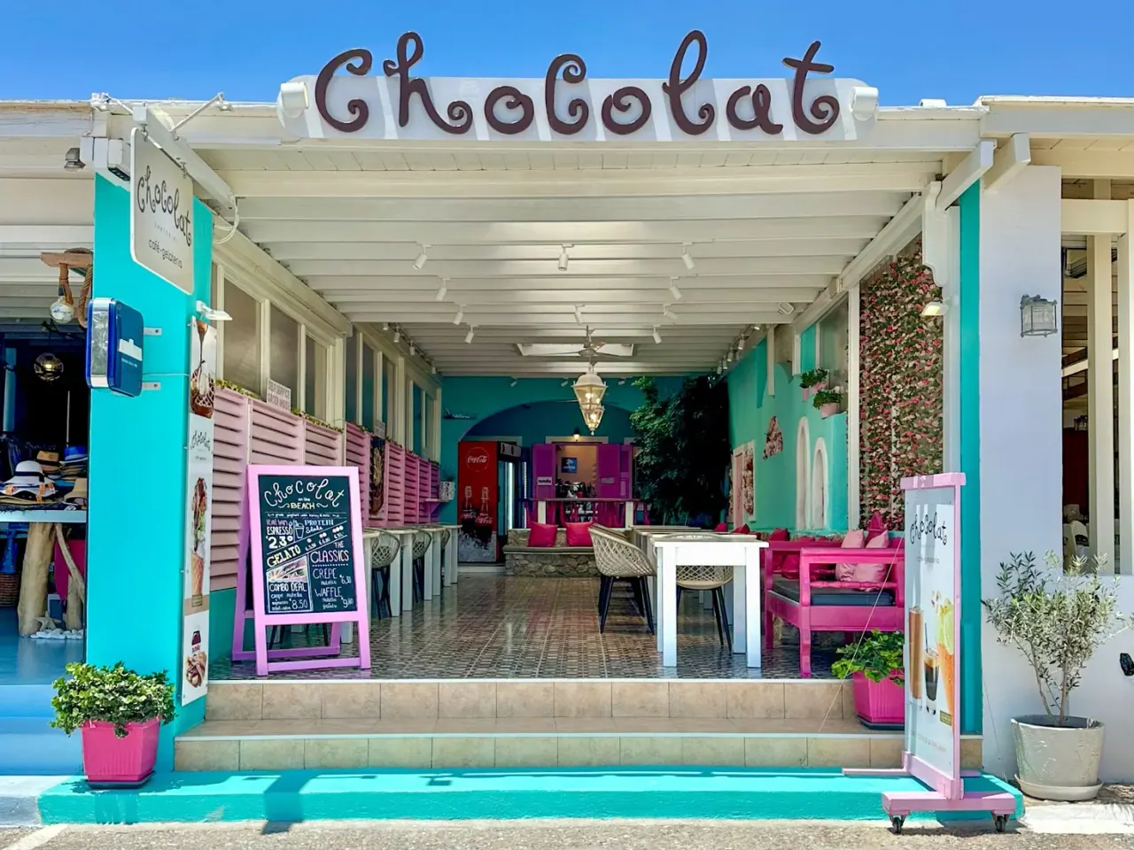 The turquoise-and-pink storefront of Chocolat café-gelateria by Perissa Beach, Santorini