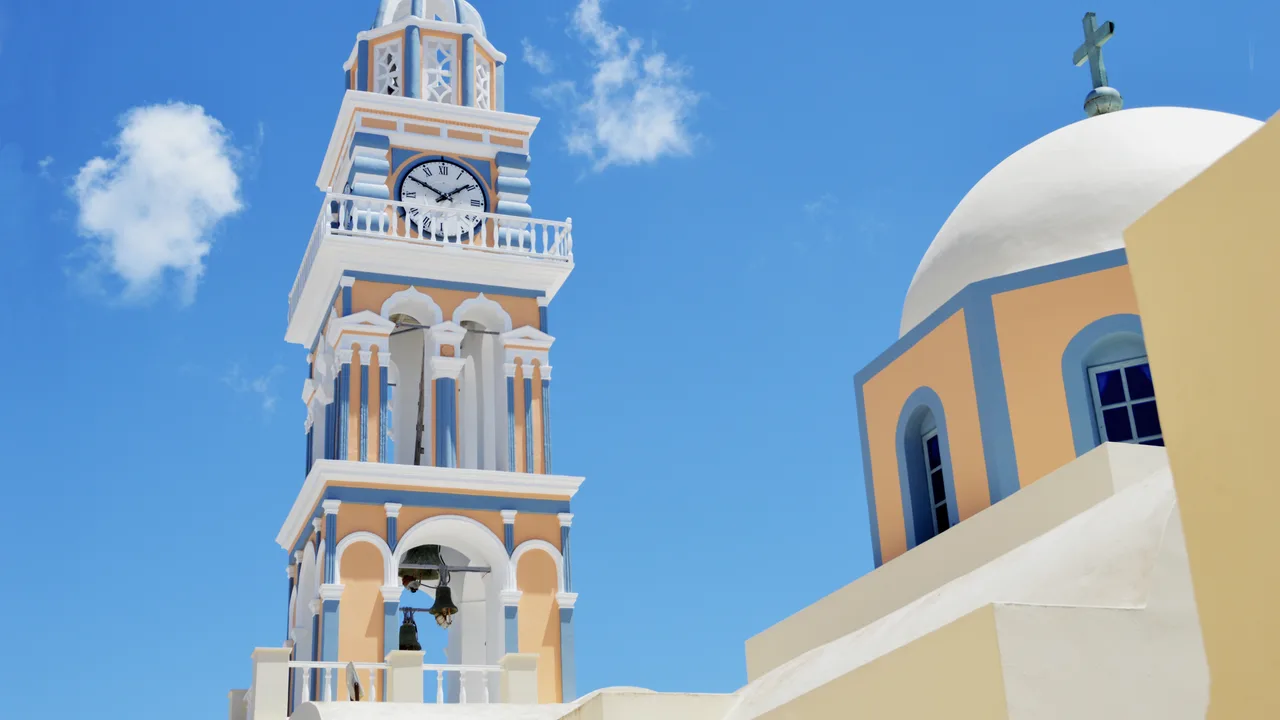 The whitewashed clifftop town of Fira above the calm Santorini caldera